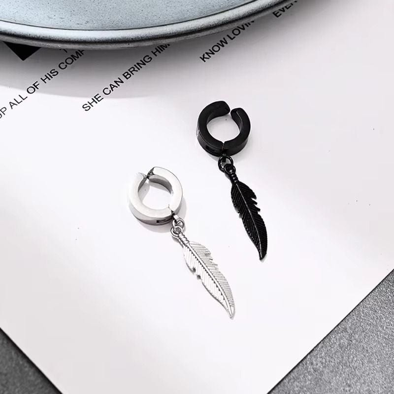 Boucles d'oreilles pendantes en acier inoxydable exposées sur une surface brillante