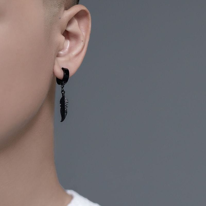 Zoom sur une boucle d'oreille pendante en acier inoxydable noir, motif plume
