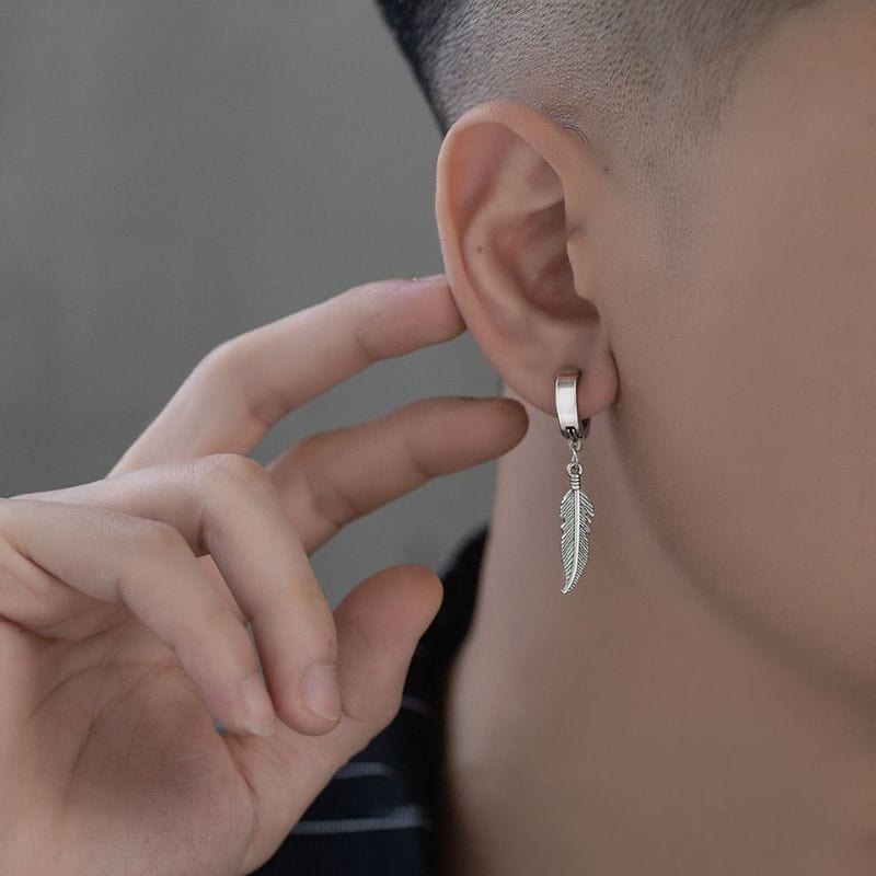 Homme portant une boucle d'oreille pendante en acier inoxydable argenté, design plume