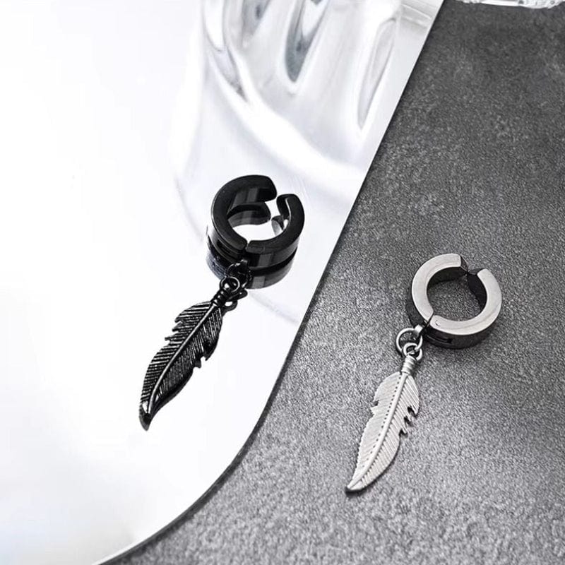 Zoom sur une paire de boucles d'oreilles en acier inoxydable noir et argent, design plume