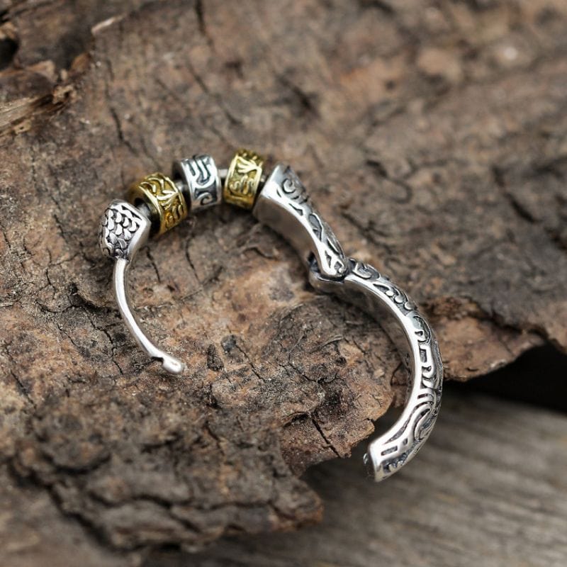 Gros plan sur une boucle d’oreille anneau homme style viking avec un fermoir sécurisé et des perles mobiles