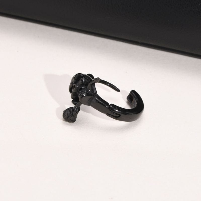 boucle d’oreille crâne noir avec rose sur fond blanc