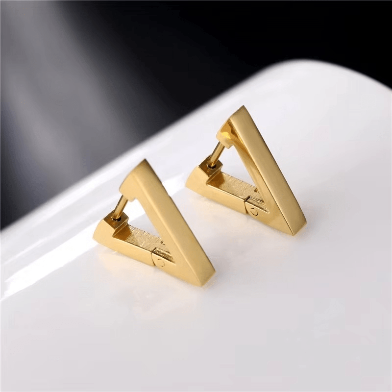 Paire de boucles d’oreilles triangle dorées en acier inoxydable sur fond blanc