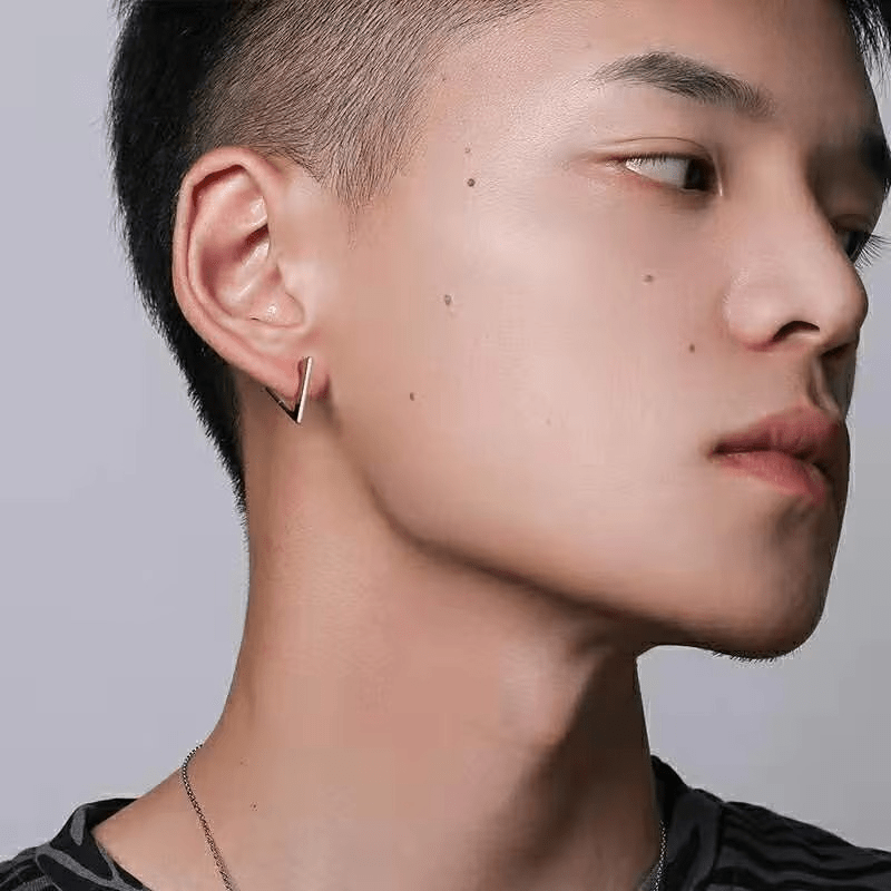 Homme portant une boucle d’oreille triangle dorée – Look tendance et minimaliste