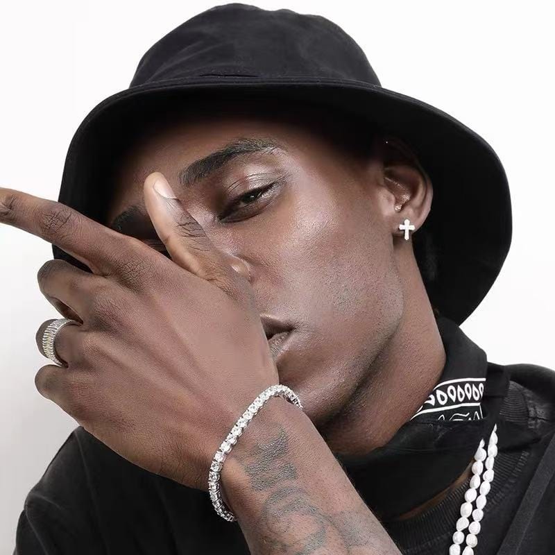 Homme portant une boucle d’oreille croix effet diamant, look streetwear et moderne
