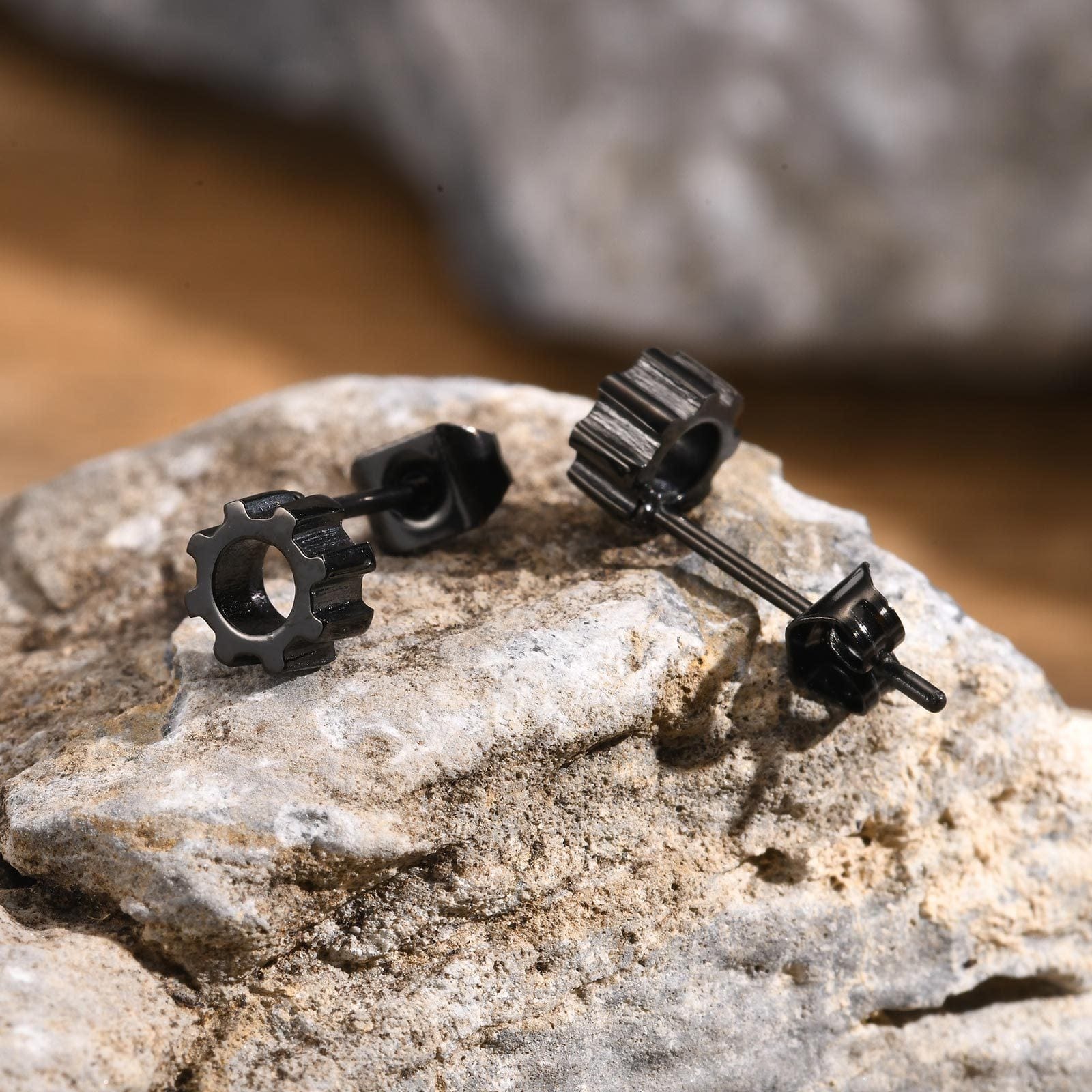 Boucles d'oreilles engrenage posées sur pierre, style industriel masculin