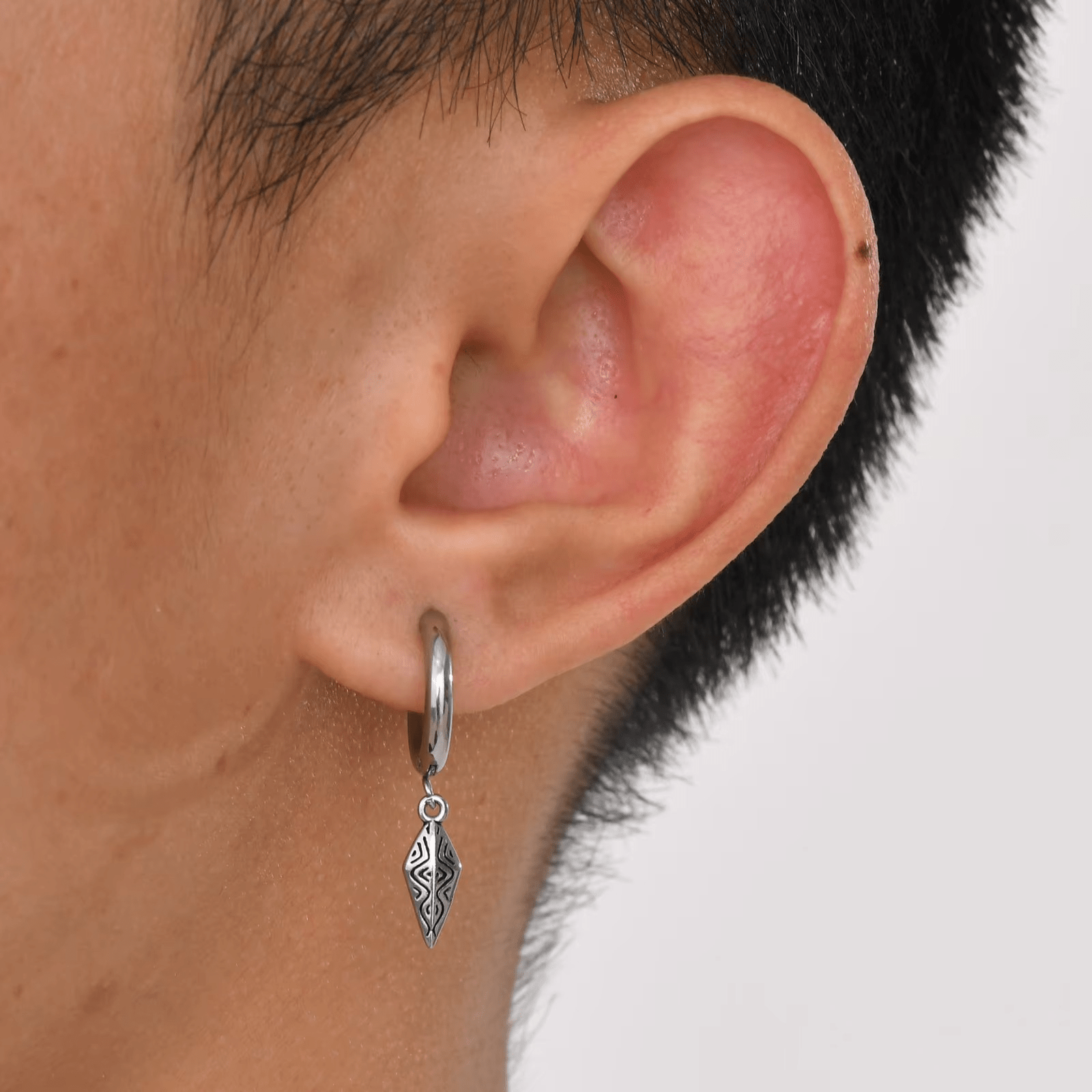 Boucle d’oreille pendante en acier inoxydable argenté pour homme avec détail gravé suspendu à un anneau