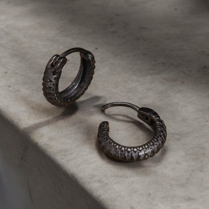 Anneaux noirs pour homme en acier inoxydable, design texturé avec motif écaillé discret pour un style masculin et élégant.