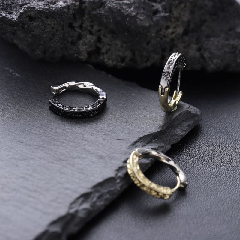 boucles d'oreilles créoles homme en acier inoxydable, finition noir brillant et argent. Le fermoir invisible garantit confort et simplicité d'utilisation. Bijou discret pour homme moderne soucieux de son apparence