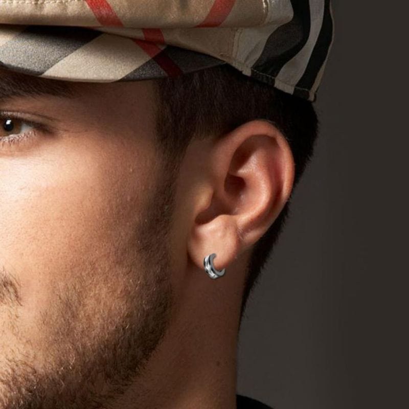 Vue de profil d’un homme portant une créole en acier inoxydable à motif plume