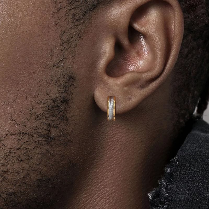 Homme à la peau foncée portant une créole dorée avec motif plume