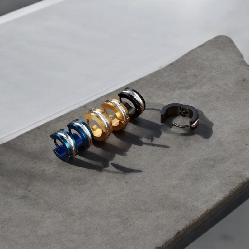 Lot de quatre créoles homme en noir et or avec gravure plume posées sur bois