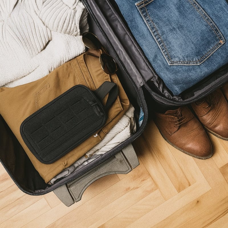 Trousse de toilette noire pour homme rangée dans une valise de voyage