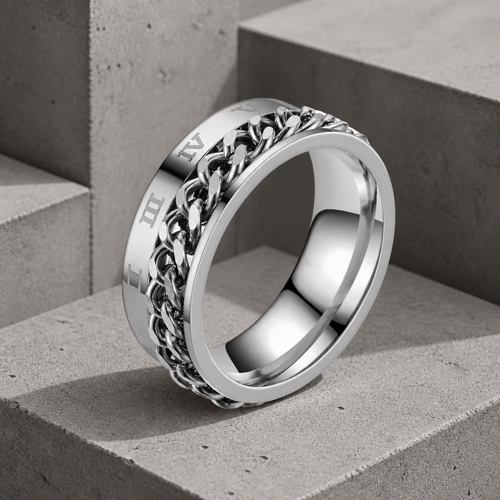 Bague homme chaîne en acier poli, gourmette tournante et chiffres romains gravés, sur béton