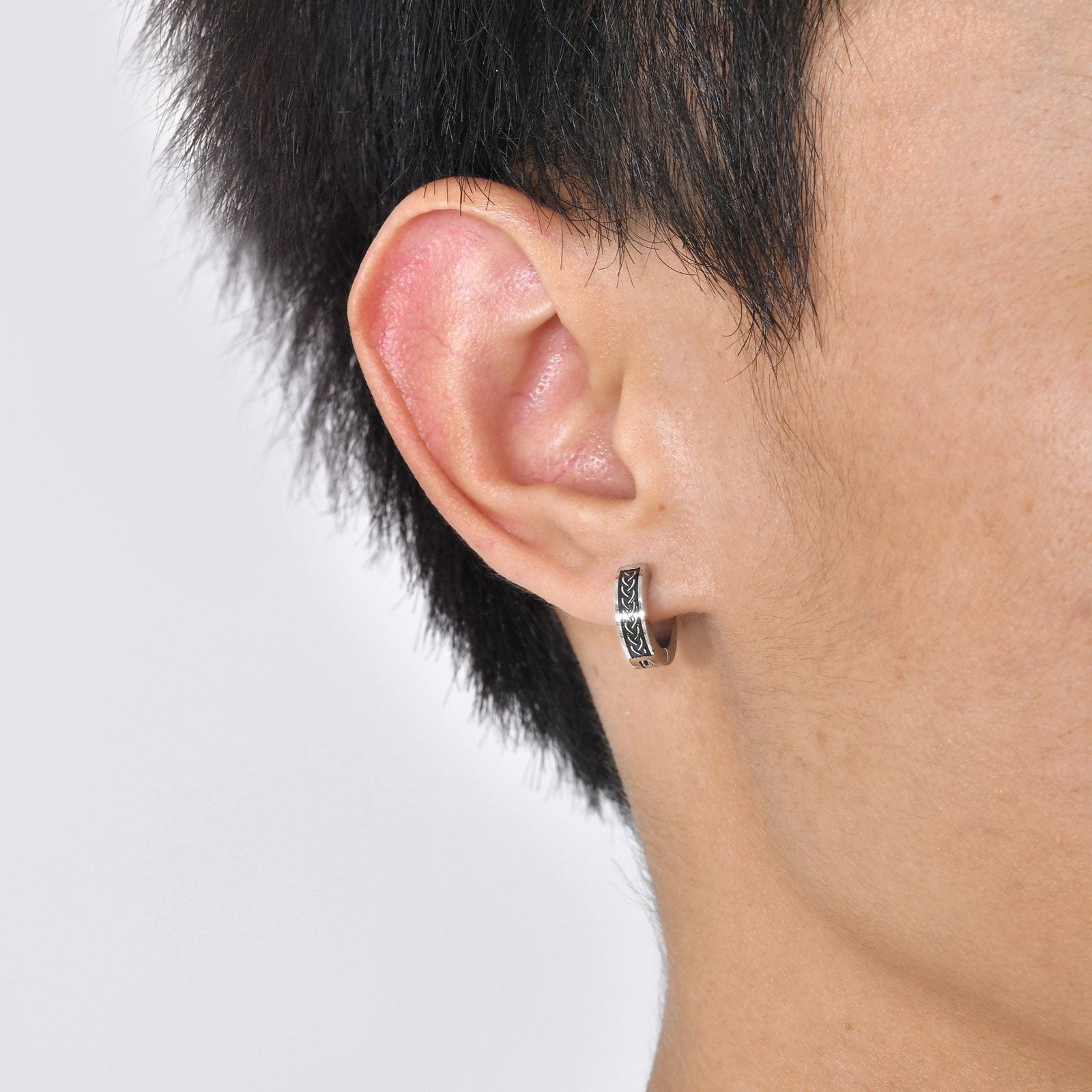 Homme portant une boucle d'oreille viking en acier inoxydable avec gravure celtique