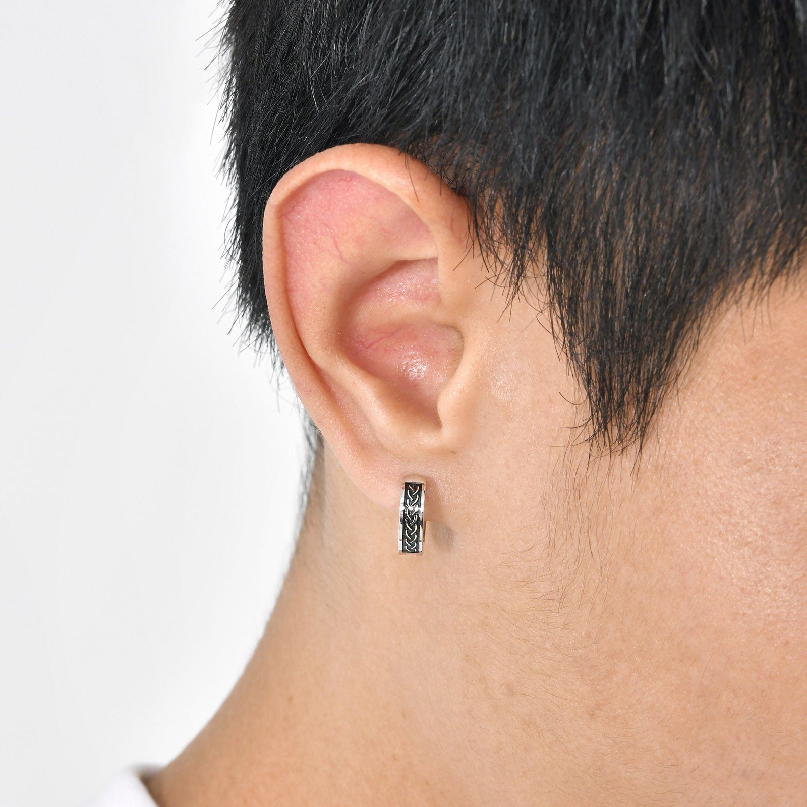 Vue latérale d’un homme portant une créole viking en acier inoxydable, motif celtique noir