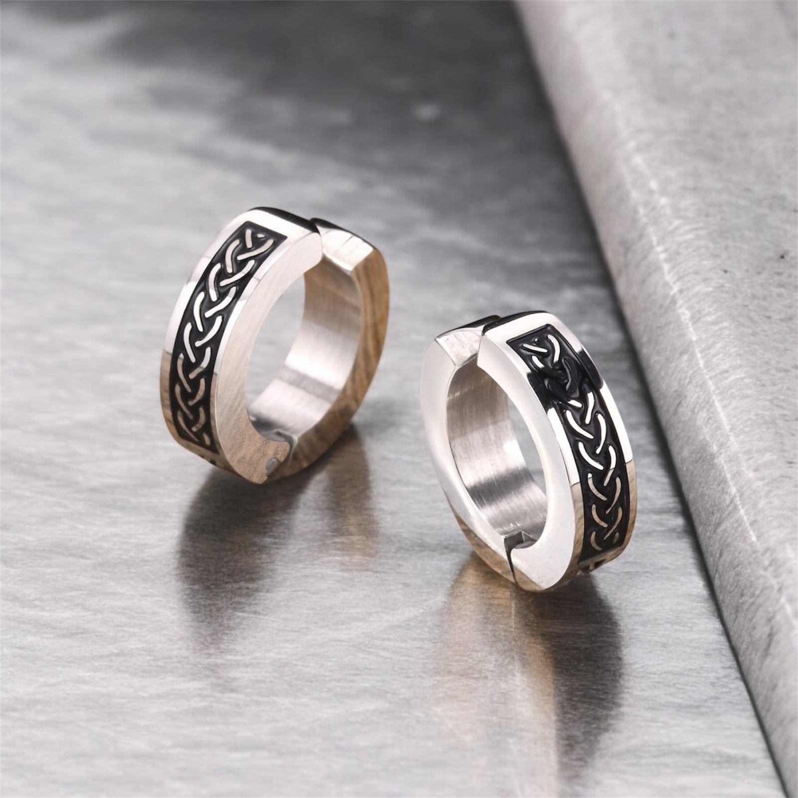 Boucles d'oreilles créoles viking en acier inoxydable, design celtique noir sur fond en bois