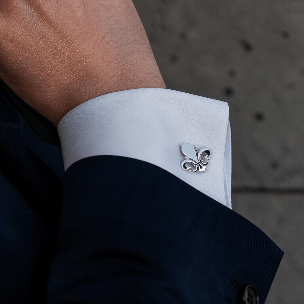 Homme portant un bouton de manchette fleur de lys argent sur une chemise à poignets mousquetaire