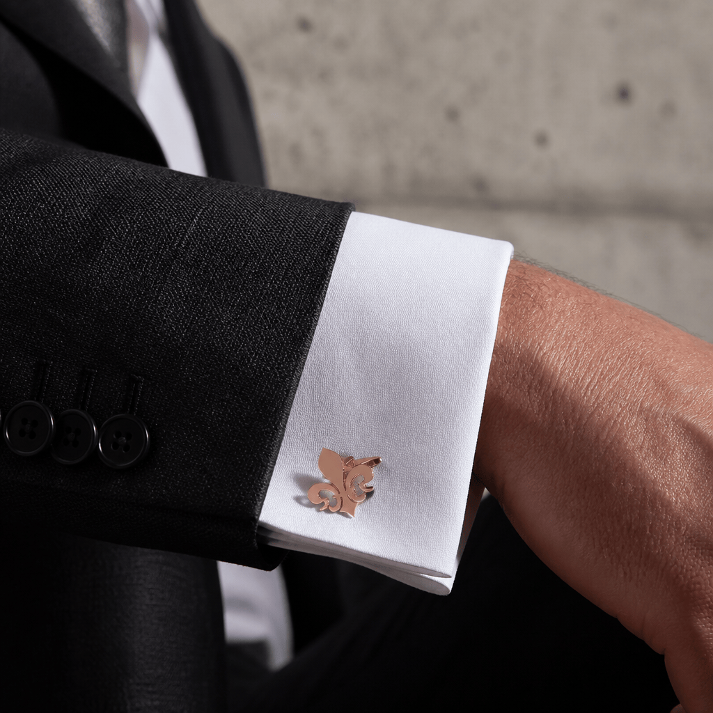 Homme portant un bouton de manchette fleur de lys or rose sur une chemise à poignets mousquetaire