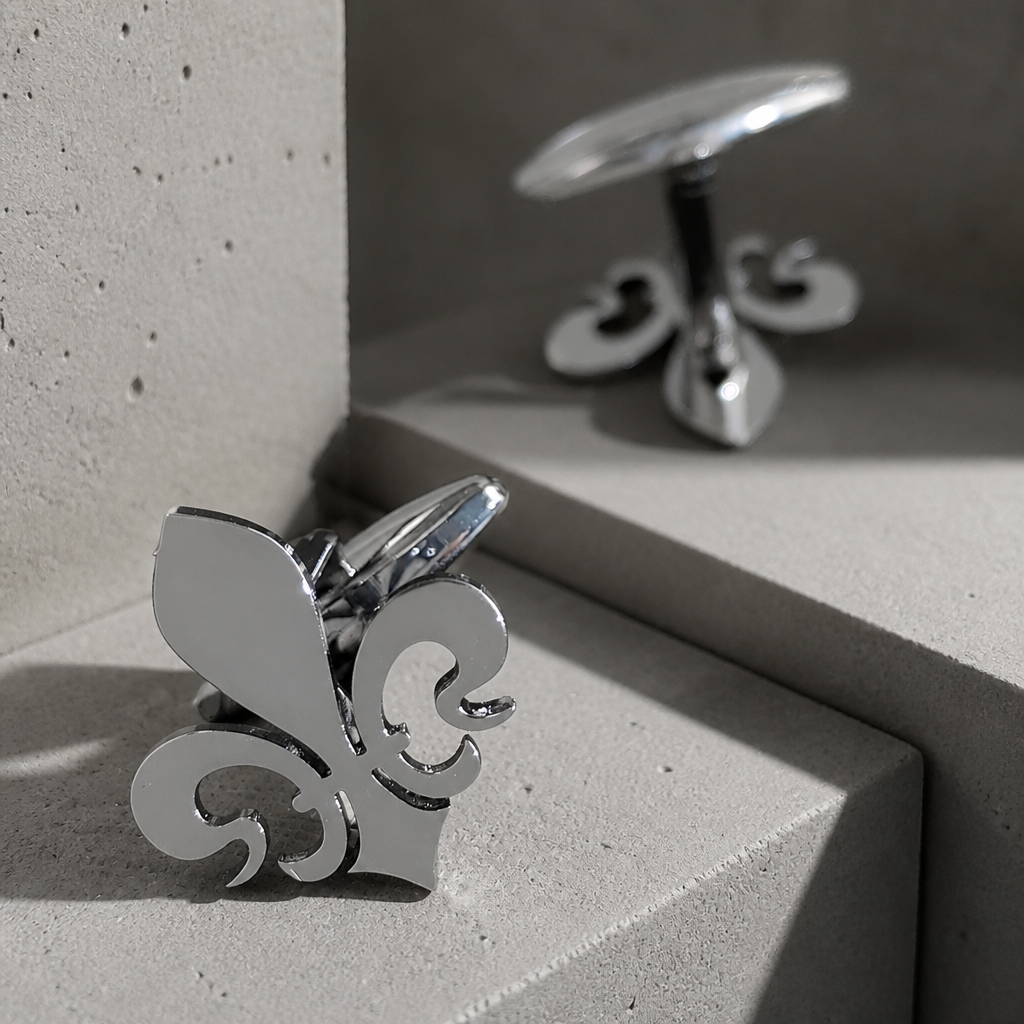 Bouton de manchette fleur de lys argent en acier sur béton