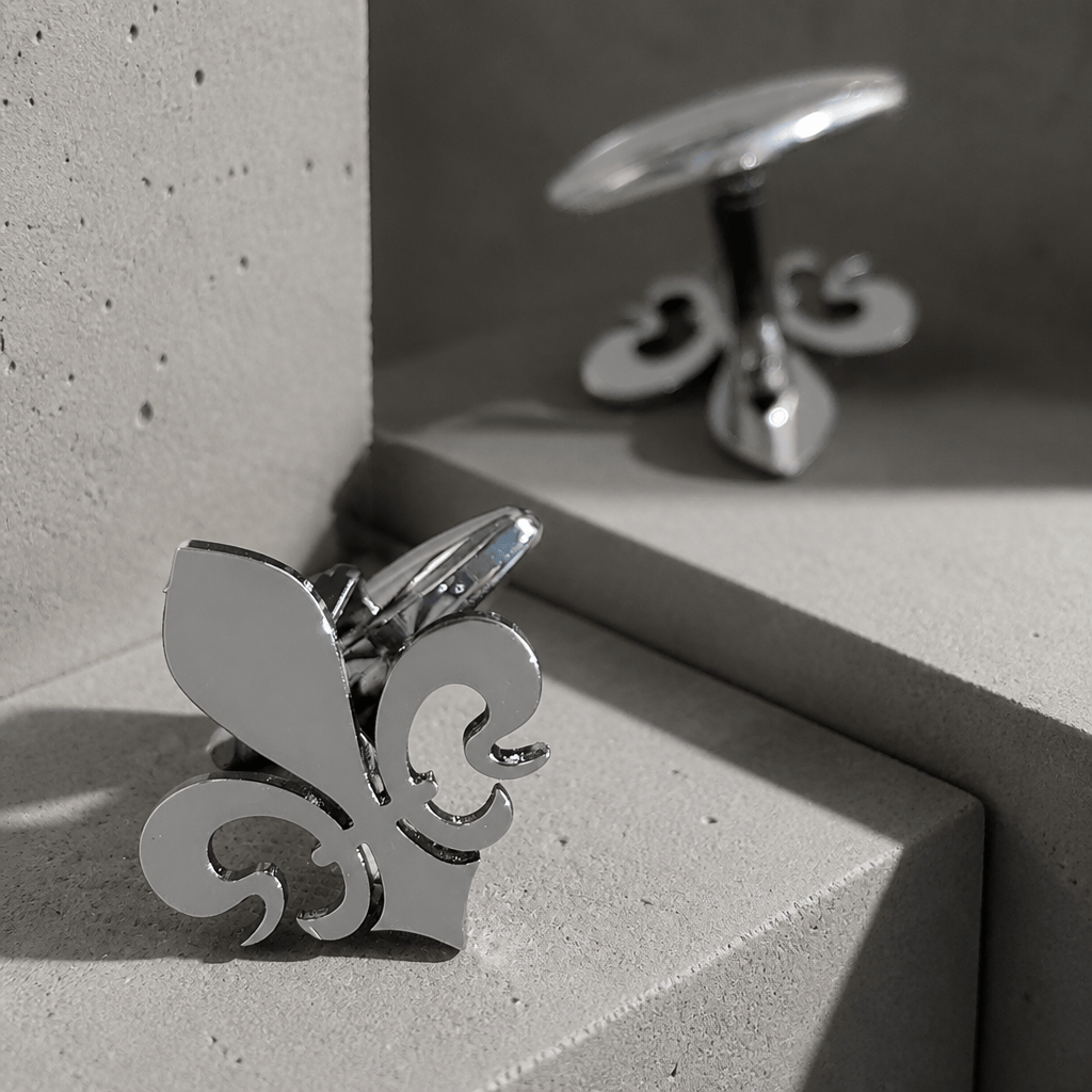 Bouton de manchette fleur de lys argent en acier sur béton