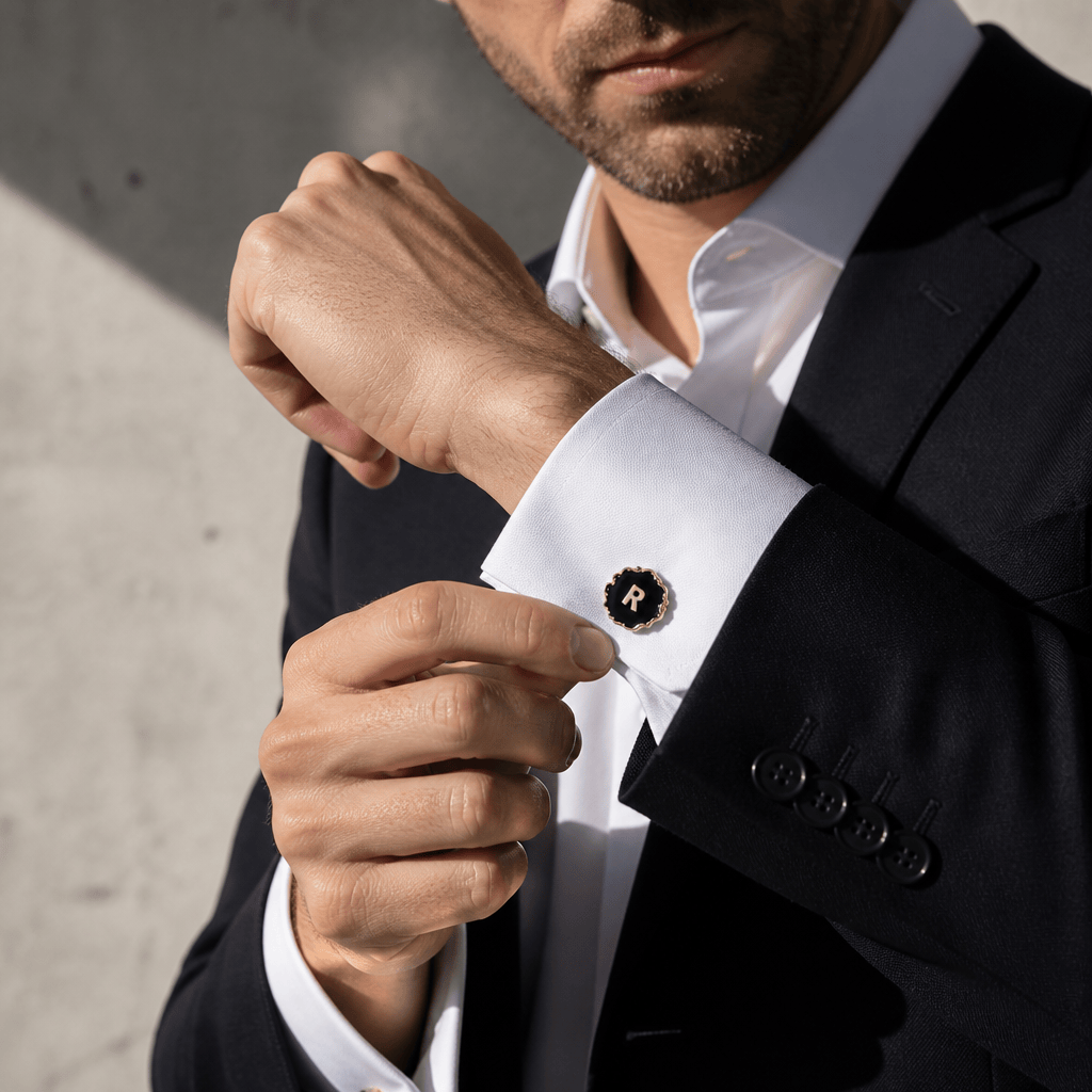 Bouton de manchette initiale R porté sous une veste de costume