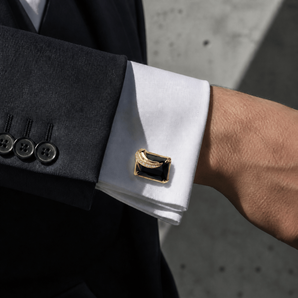 Bouton de manchette noir doré porté sur une chemise à poignet mousquetaire