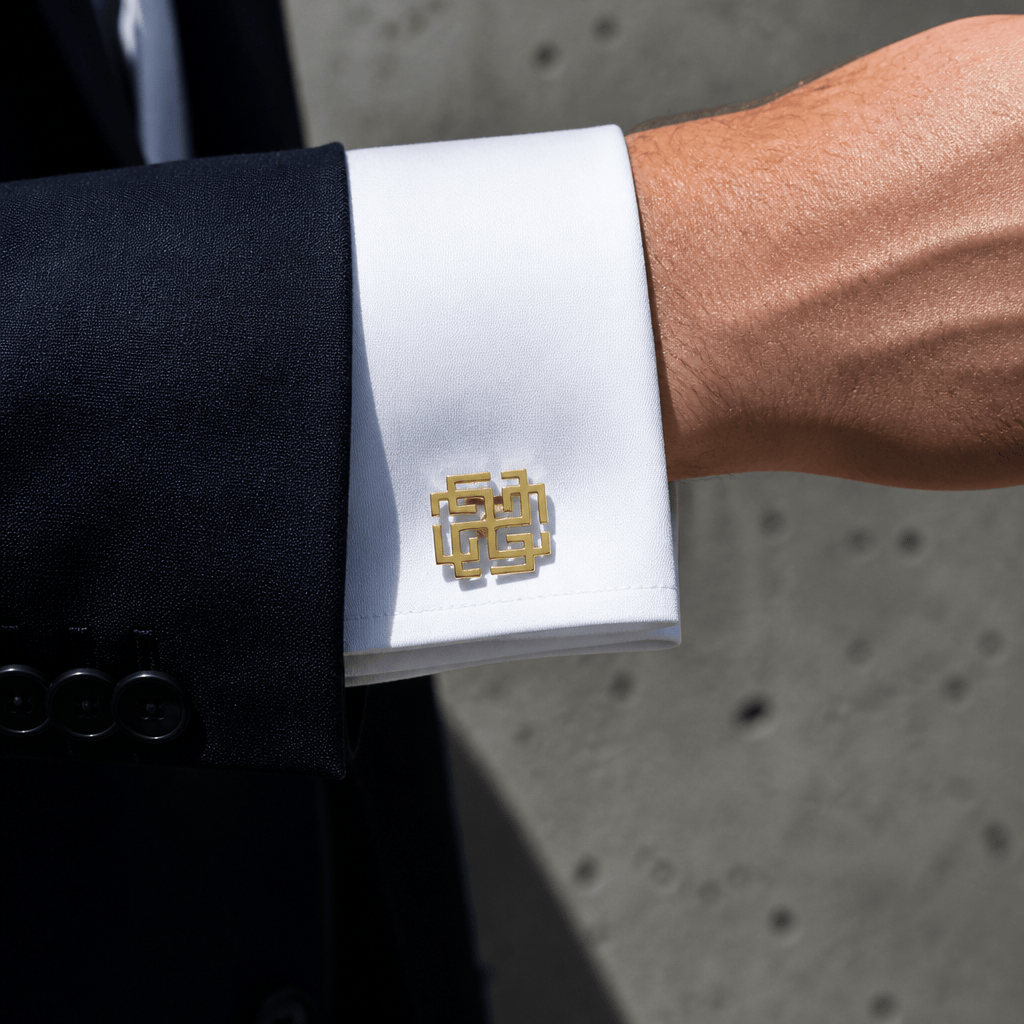 Bouton de manchette original or porté sur un poignet mousquetaire de chemise blanche