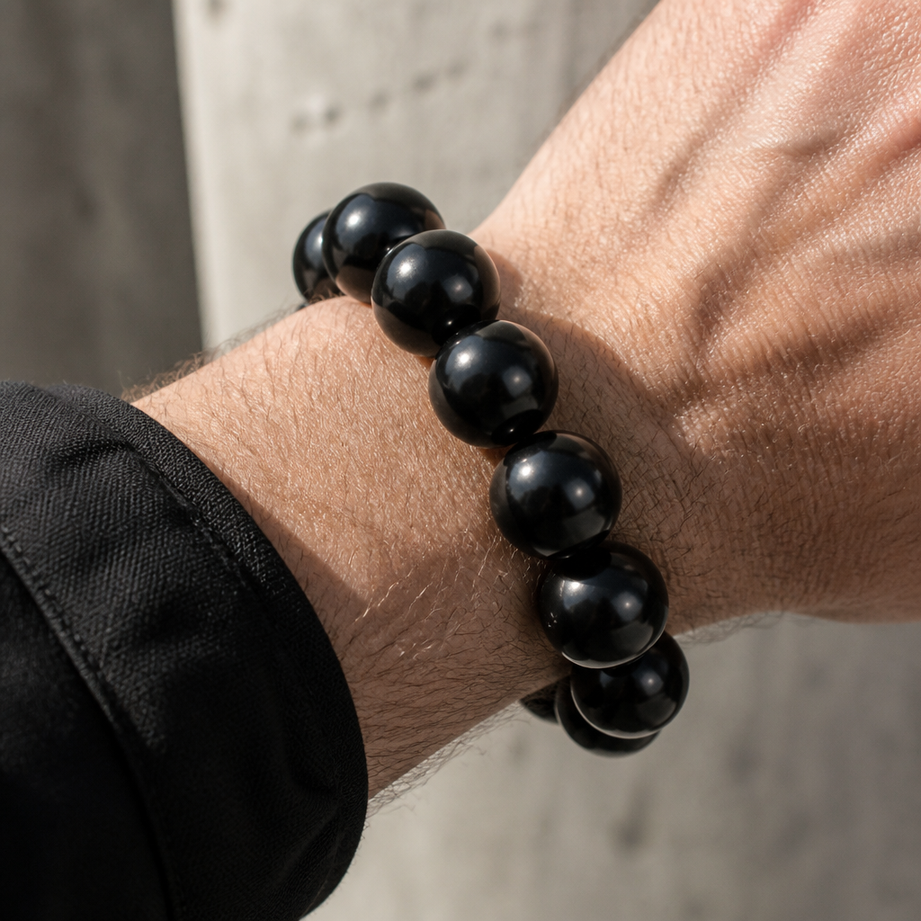 Bracelet boule homme en bois noir porté au poignet d'un homme