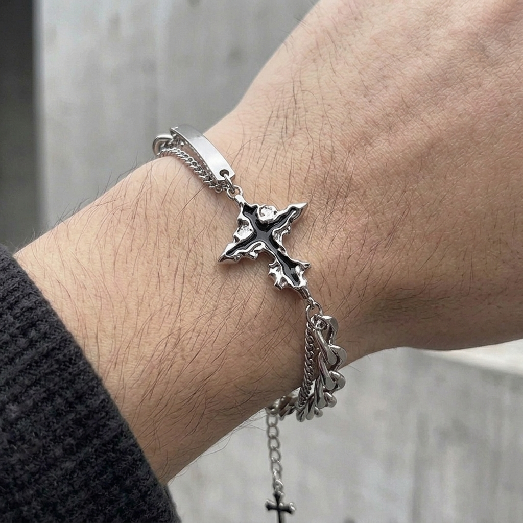 Bracelet croix homme argent porté au poignet, manche de maille noire remontée