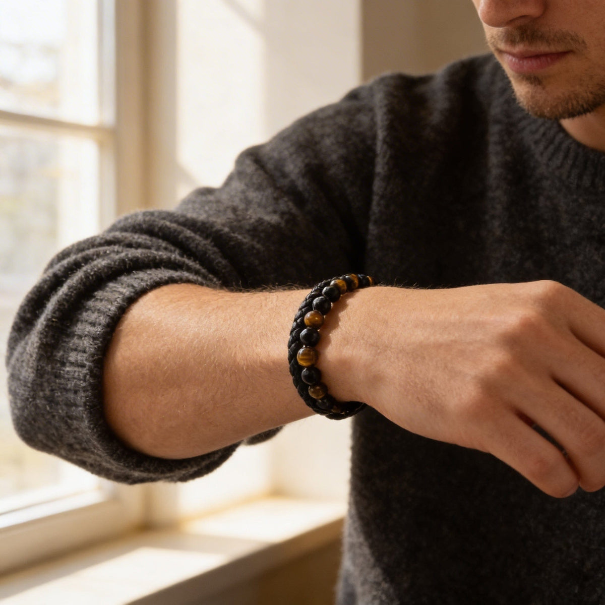 Homme portant le bracelet perles d'œil de tigre et cuir tressé au poignet