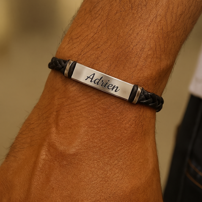 Bracelet homme gravé porté au poignet, plaque bombée en acier sur cordon noir