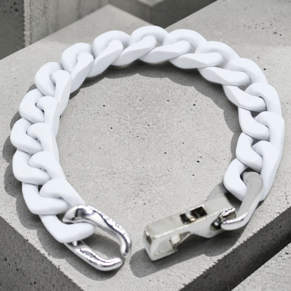 Bracelet homme en maille cubaine laquée blanche, packshot sur béton clair