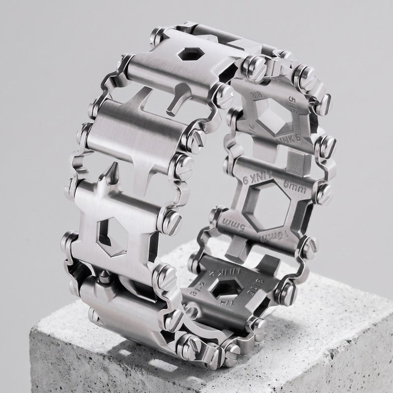 Bracelet homme outil en acier brossé posé sur un bloc de béton