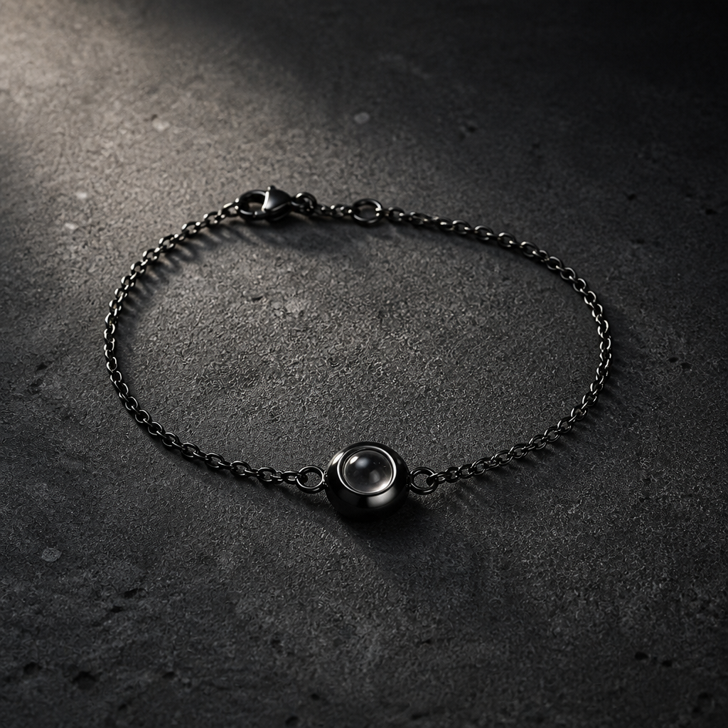 Bracelet photo chaîne fine finition noire sur béton sombre