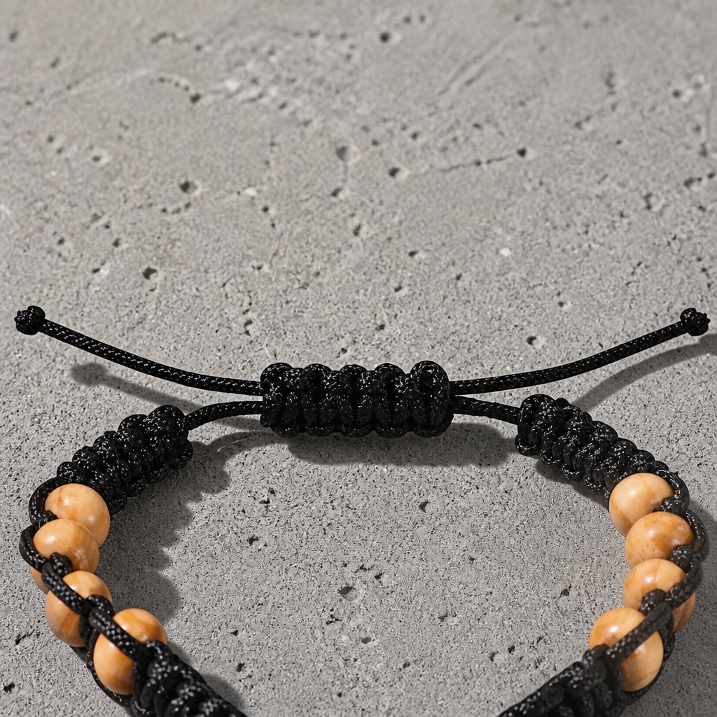 Noeud coulissant du bracelet perle croix homme, tressage noir et brins libres