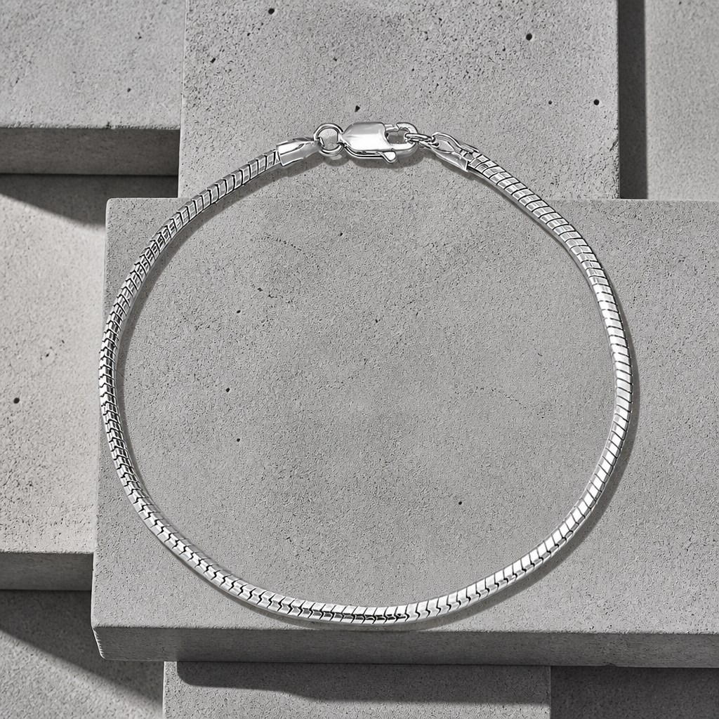 Bracelet snake argent homme, maille serpent plate fermée en cercle sur fond de béton