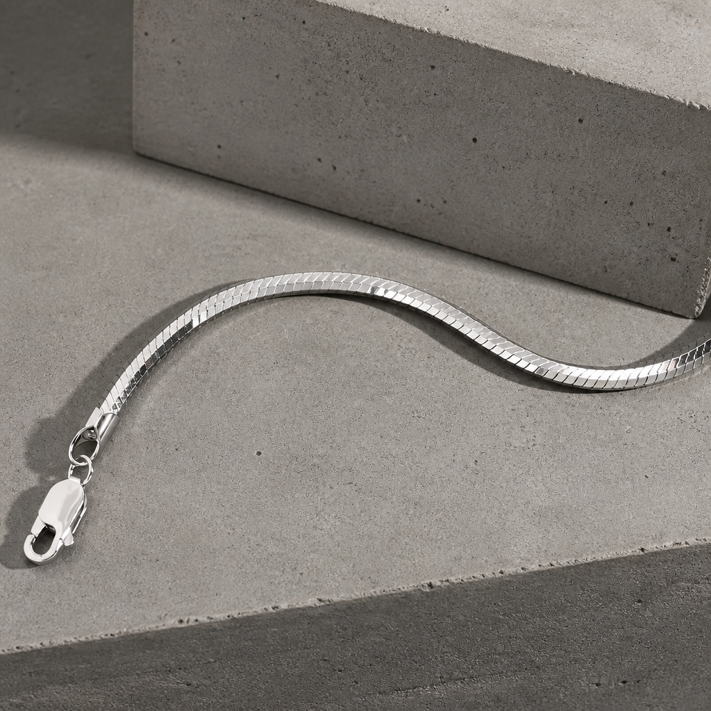 Chaîne serpent en argent posée en courbe, fermoir mousqueton visible