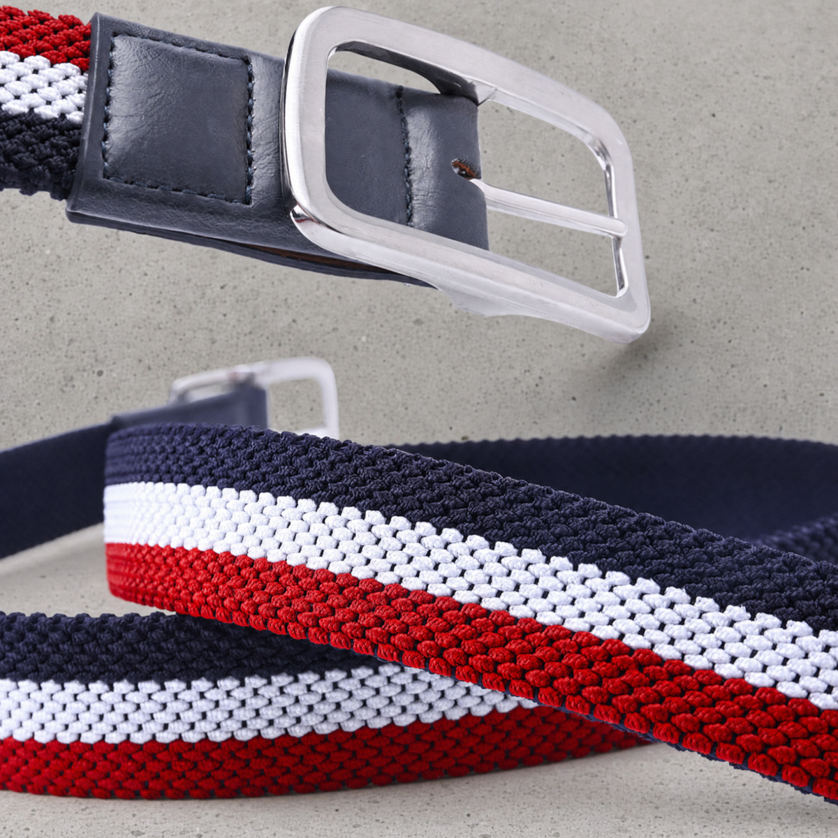 Détail de la boucle à ardillon argent brossé et de la patte en similicuir bleu marine de la ceinture golf homme