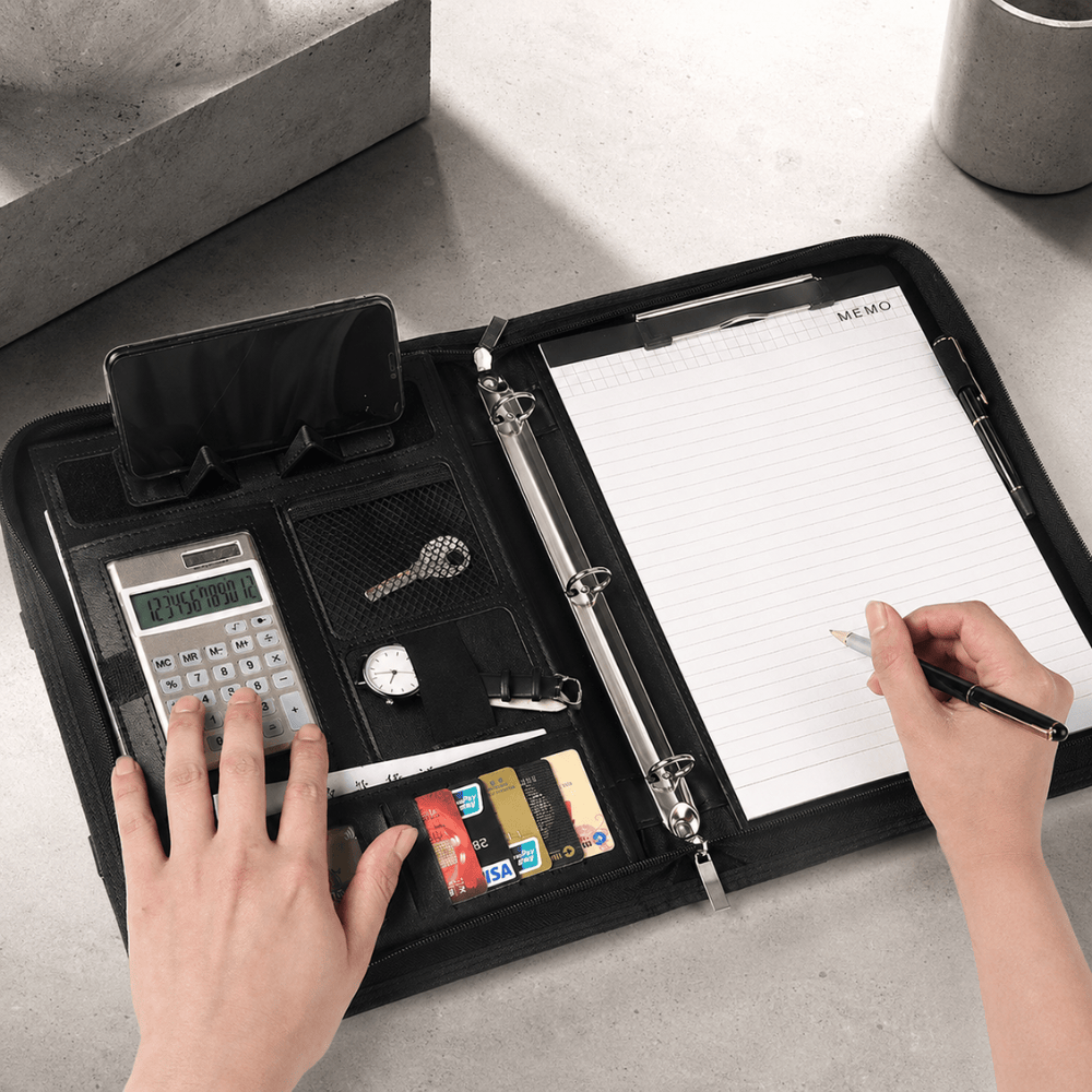 Classeur porte-document en usage sur un bureau : calculatrice, bloc-notes MEMO et prise de notes