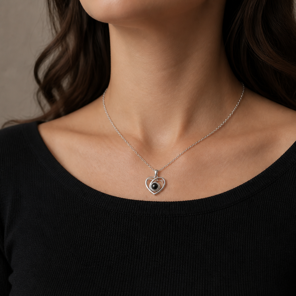 Collier cœur ajouré photo projection argent porté avec un haut noir