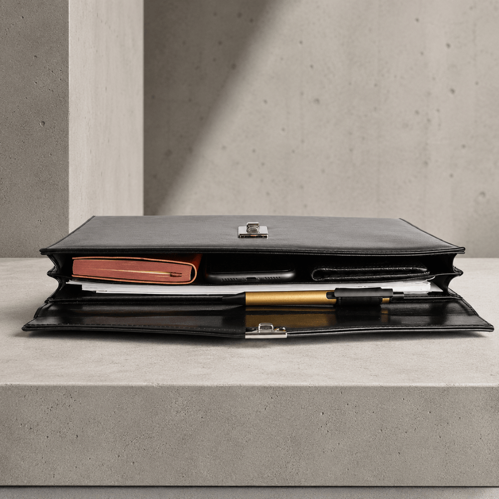 Porte-document ouvert montrant l'intérieur avec carnet, téléphone, stylo et documents A4