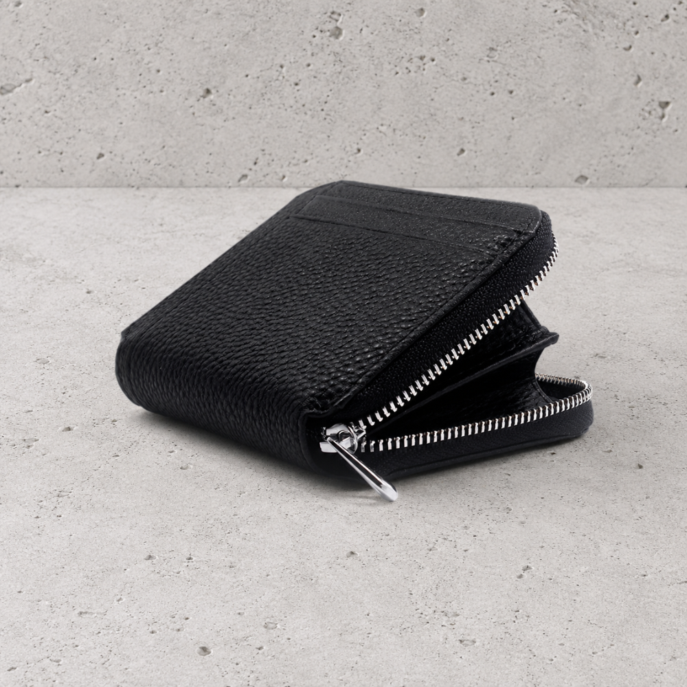 Porte-monnaie homme en cuir noir ouvert montrant le compartiment zippé