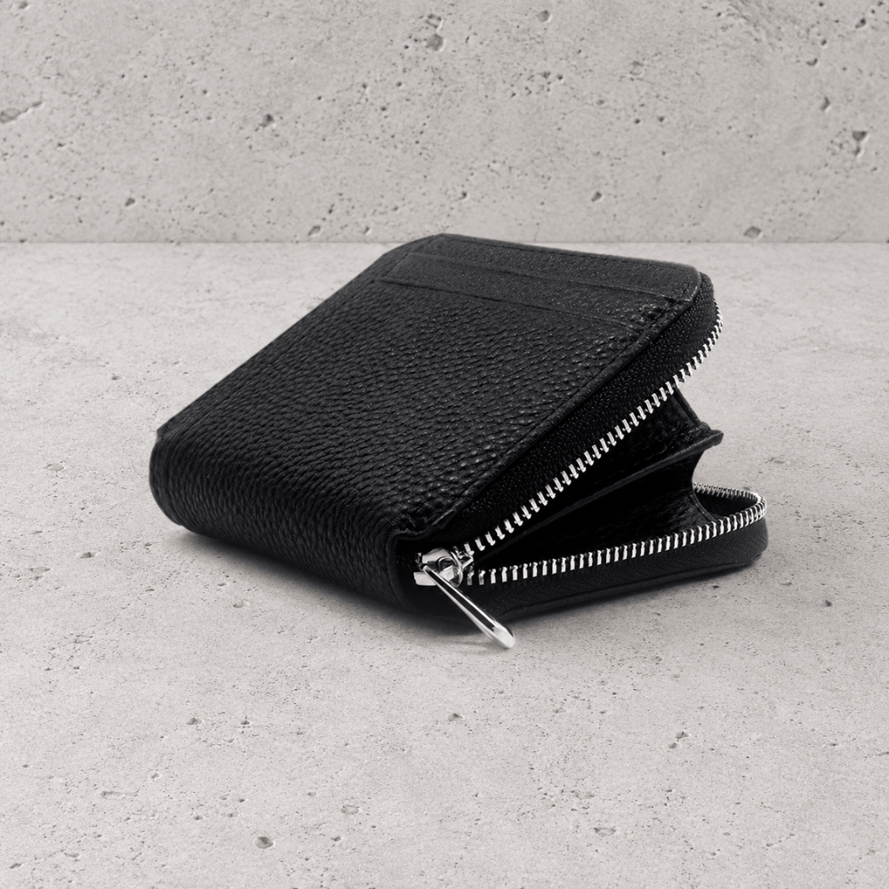 Porte-monnaie homme en cuir noir ouvert montrant le compartiment zippé