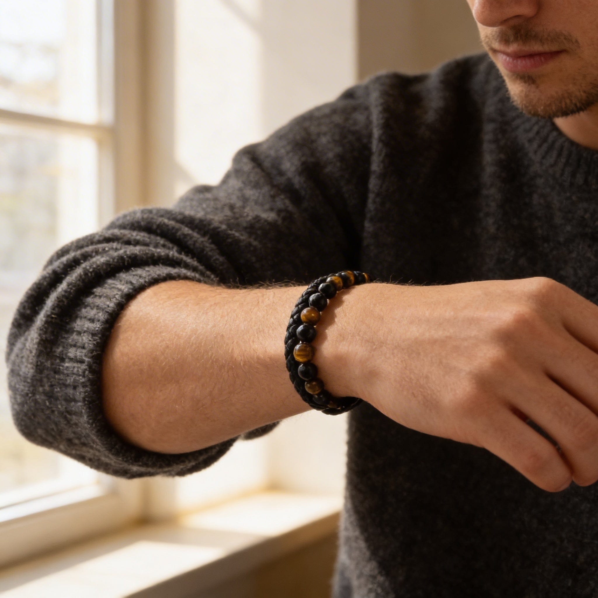 Homme portant un bracelet en cuir tressé et perles d'œil de tigre au poignet