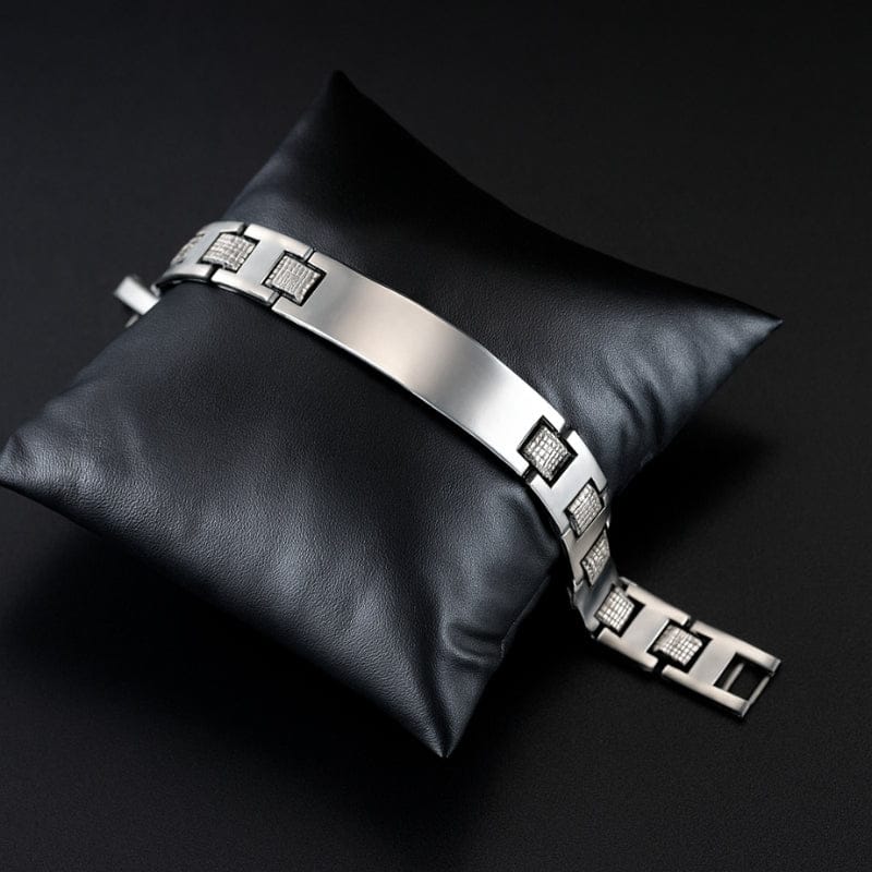 Bracelet homme haut de gamme en acier présenté sur un coussin en cuir