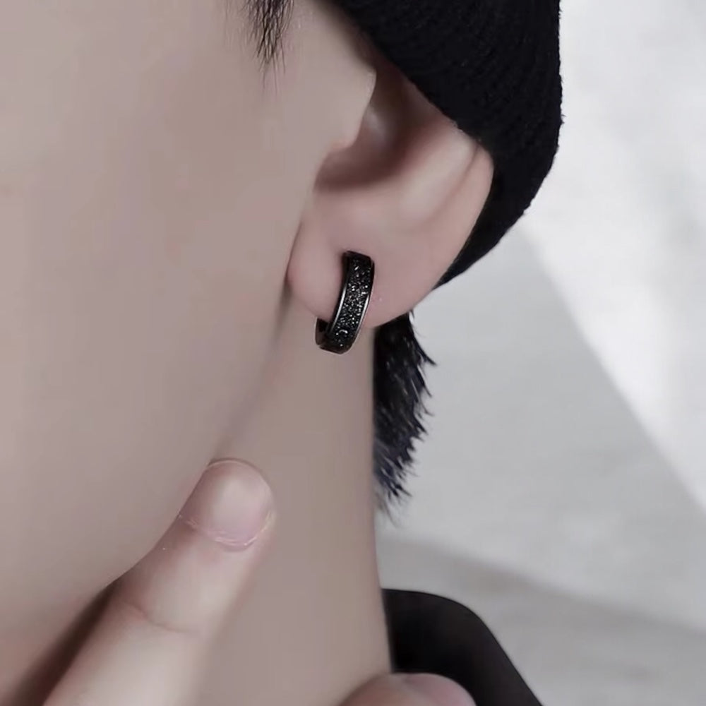 Boucle d’oreille noire en acier inoxydable portée par un homme – Style tendance et discret, idéal pour un look moderne 
