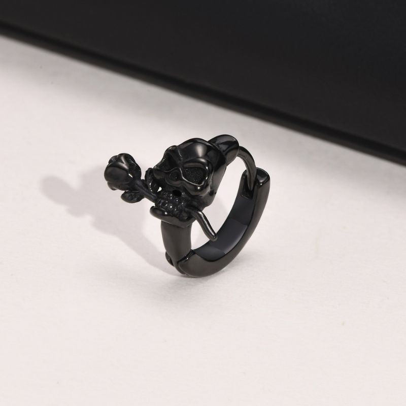 boucle d’oreille homme noire tête de mort avec rose en gros plan