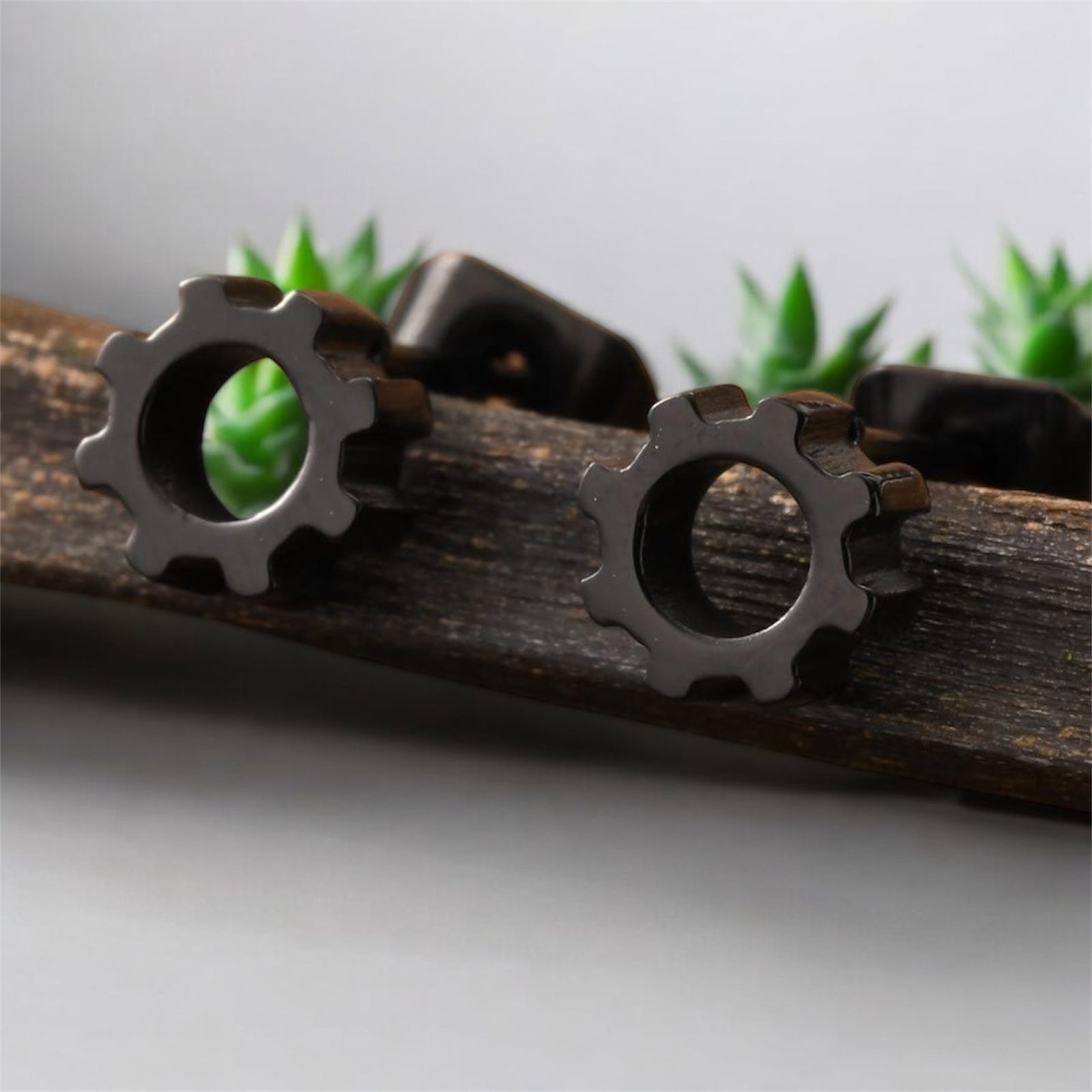 Boucles d'oreilles homme acier inoxydable sur support en bois, design mécanique 