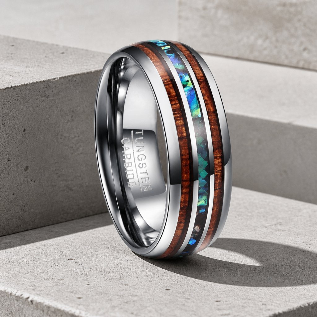 Bague homme en tungstène argenté, deux bandes de bois et une bande de nacre, posée sur béton